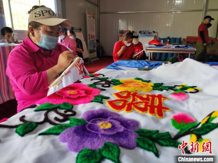 圖為婦女制作青繡?！?zhí)砀?攝