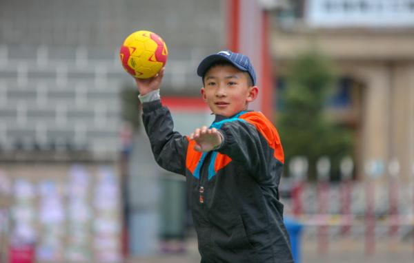 在高原上教孩子們打手球，“慢慢兒來(lái)，甭著急！”