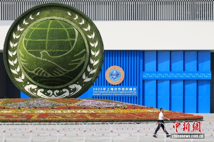 8月31日，天津，一名工作人員從2025年上海合作組織峰會主會場外的景觀花壇旁經(jīng)過。當(dāng)日，2025年上海合作組織峰會在天津舉行。<a target='_blank' href='/'><p  align=