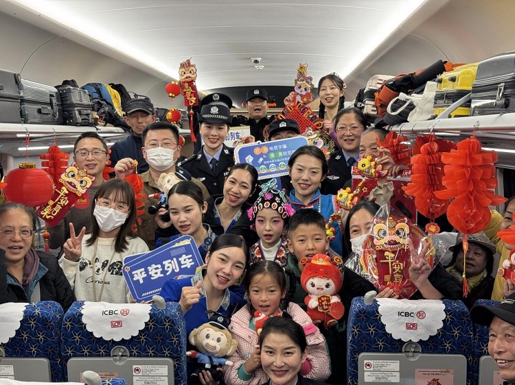 春節(jié)期間，在中老鐵路磨萬（磨丁—萬象）段，鐵路客運員工與乘客合影留念。李加勇攝