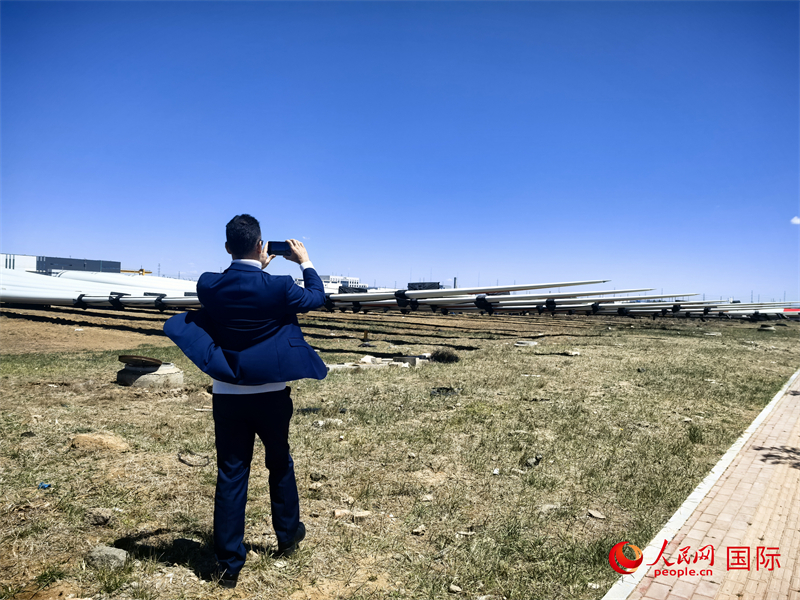 外媒記者拍攝廠房外的風力渦輪發(fā)電機的巨型漿葉。人民網(wǎng) 楊春燕攝