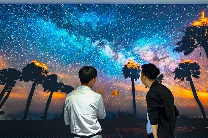 長(zhǎng)春光博會(huì)希達(dá)電子展區(qū)，一位工作人員正在給一位觀眾講解。（長(zhǎng)春新區(qū)供圖）