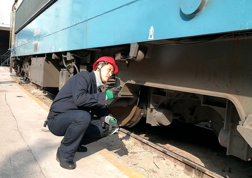 韓文盛全神貫注檢查機車走行部。
