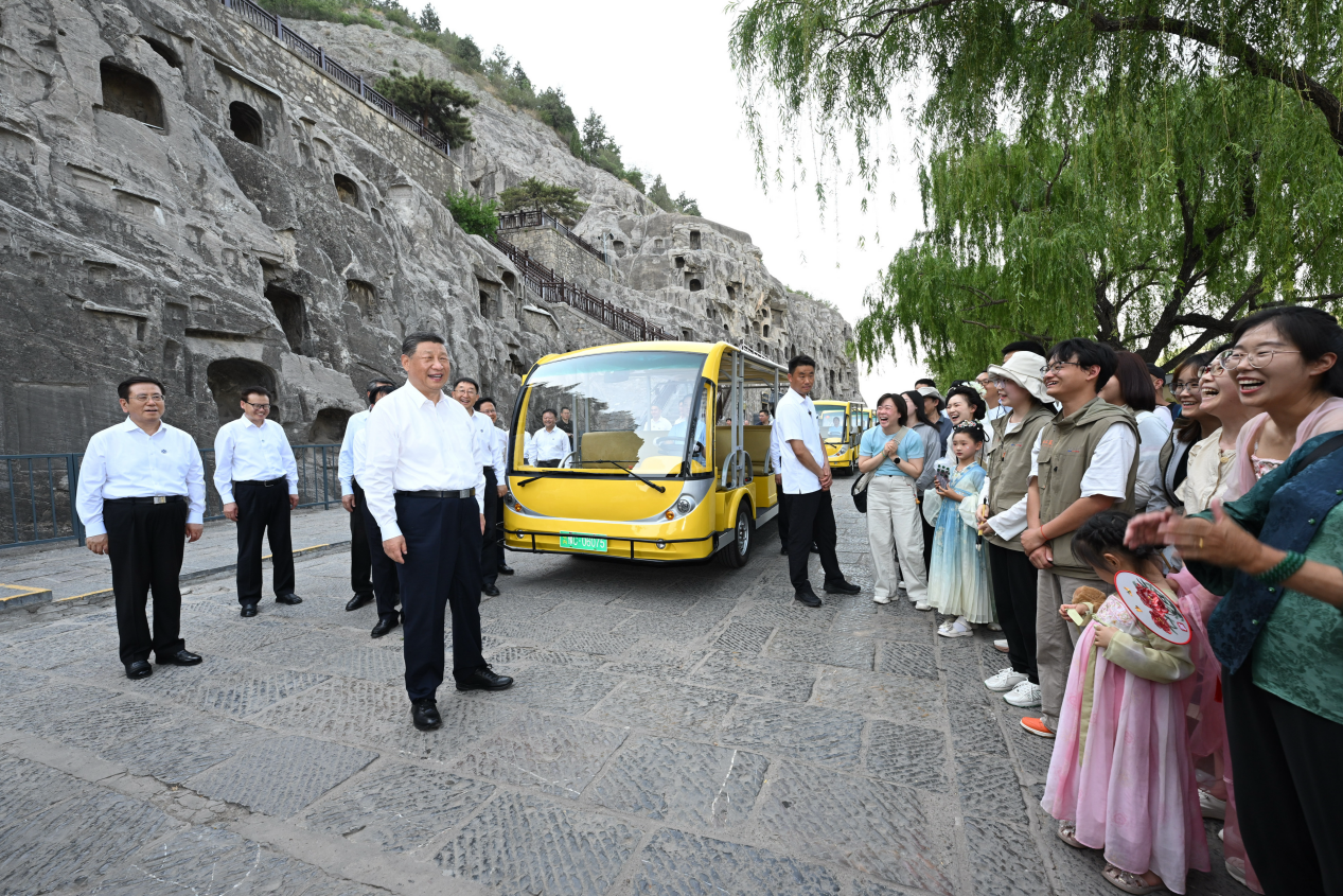 5月19日，習近平在洛陽龍門石窟考察時，同游客親切交流。