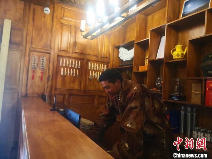 圖為桑杰才讓用電腦處理財務。　史靜靜 攝