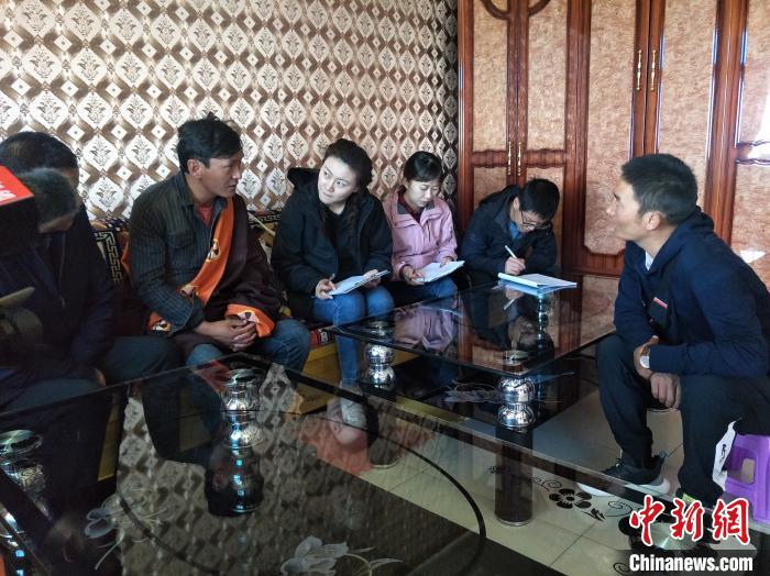 圖為調(diào)查組工作人員正在入戶調(diào)查?！∑钤鲚?攝