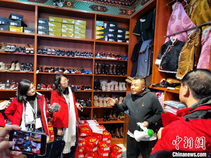 圖為中外媒體在玉樹州玉樹市甘達(dá)村采訪?！?zhí)砀?攝