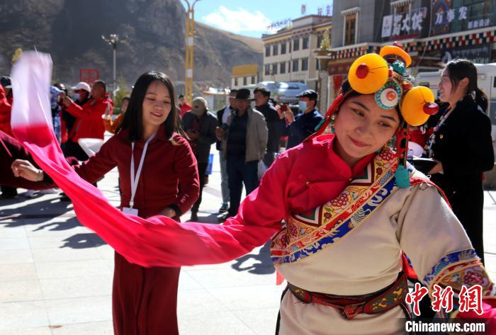 圖為中外記者向當?shù)孛癖妼W(xué)習(xí)民族歌舞文化?！?zhí)砀?攝