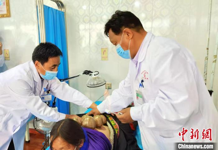 圖為看照加手把手帶徒弟加老(左一)進行拔罐療法?！堟?攝