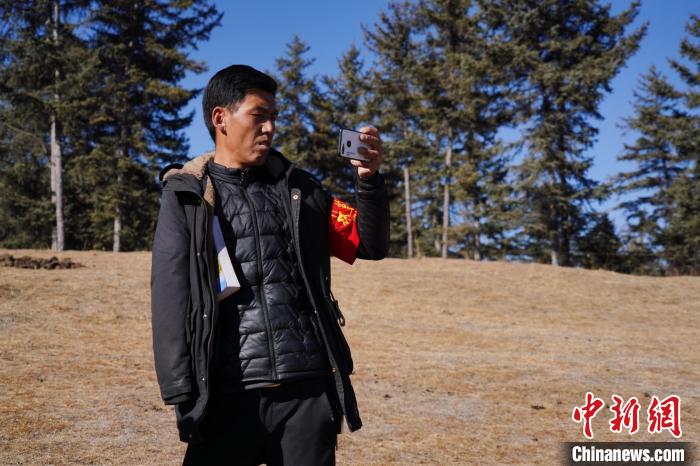 圖為桑杰加進(jìn)行巡查并拍照記錄?！●R銘言 攝