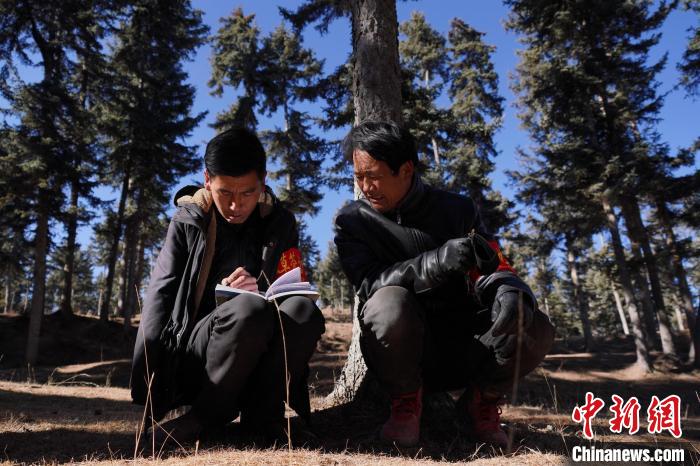 圖為桑杰加(左)和同事記錄巡查結(jié)果?！●R銘言 攝