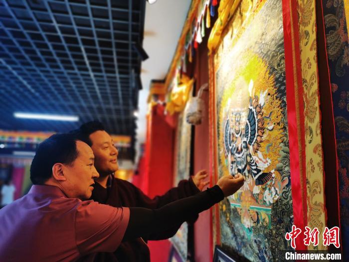 圖為久美尖措展示唐卡作品。　張?zhí)砀?攝