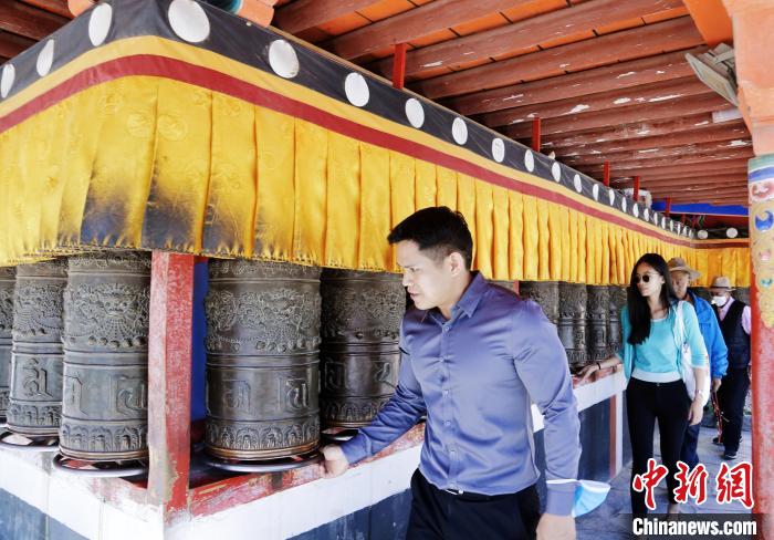 圖為外籍嘉賓體驗(yàn)藏族傳統(tǒng)轉(zhuǎn)經(jīng)筒?！●R銘言 攝