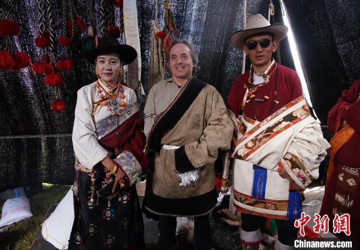 圖為一名外籍?dāng)z影師(中)身穿藏服和藏族民眾合影留念?！●R銘言 攝