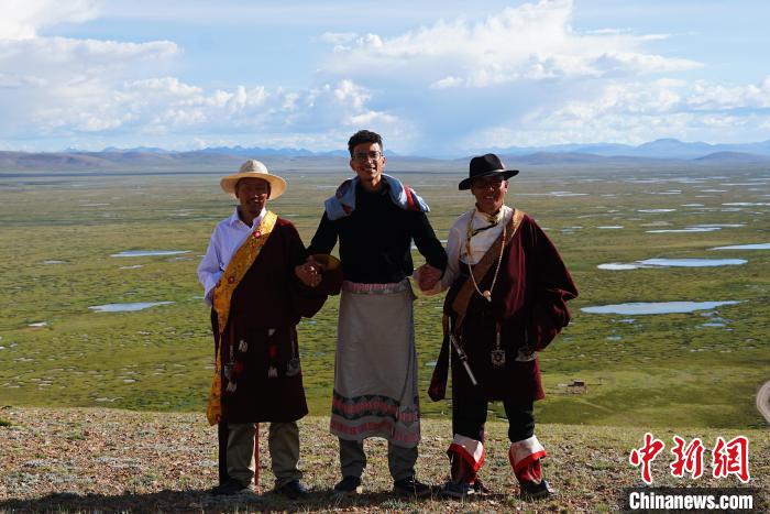 圖為一名留學(xué)生身穿自己國家的服飾和藏族民眾合影留念?！●R銘言 攝