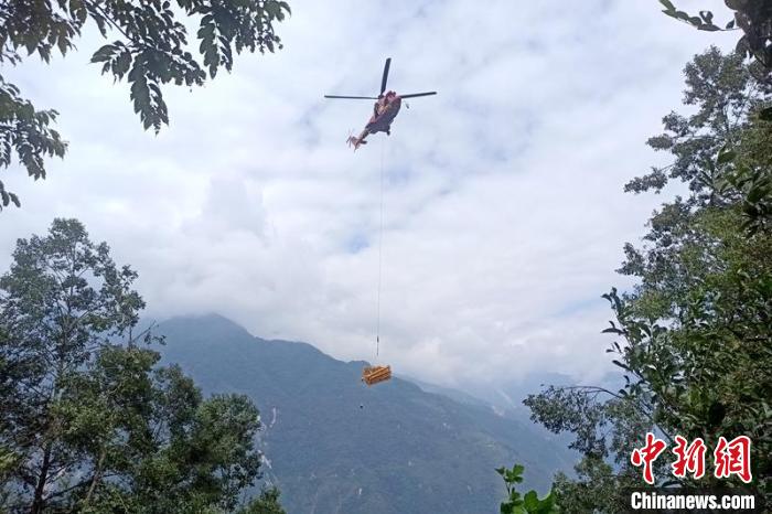 直升機起飛將搶修塔材運往海拔1950米的110千伏唐下線29號塔位?！⌒鞈c明 攝