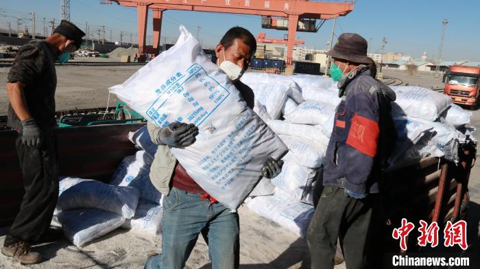 圖為裝卸人員將食鹽從汽車倒裝到火車上?！±钌?攝