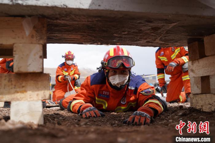 圖為地震實戰(zhàn)拉動現(xiàn)場，參演人員正在進行頂撐救援項目?！∮駱湎拦﹫D