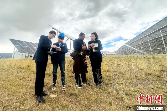 圖為稅務(wù)干部上門開展稅費輔導(dǎo)?！》劫F龍 攝