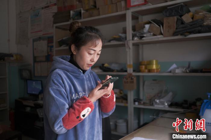 正在快遞站點內(nèi)忙碌的楊莉春?！『闻罾?攝