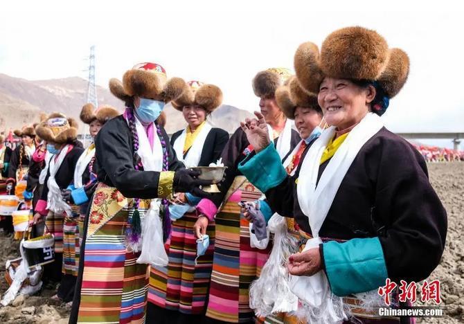 資料圖：西藏自治區(qū)拉薩市曲水縣才納鄉(xiāng)協(xié)榮村參加春耕儀式的村民互敬青稞酒。按照傳統(tǒng)，當(dāng)?shù)卮迕裆碇?jié)日盛裝，舉行隆重的儀式，祈福一年的豐收。<a target='_blank' ><p  align=