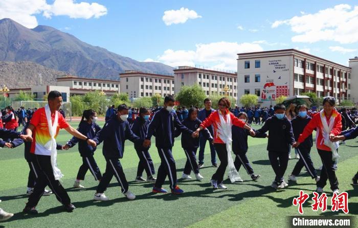 圖為世界冠軍與拉薩阿里地區(qū)高級中學(xué)學(xué)生一起跳鍋莊?！∪轿木?攝