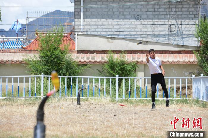 圖為西藏自治區(qū)拉薩市賽馬場(chǎng)內(nèi)市民在體驗(yàn)“打牛角”項(xiàng)目?！∝暩聛?lái)松 攝