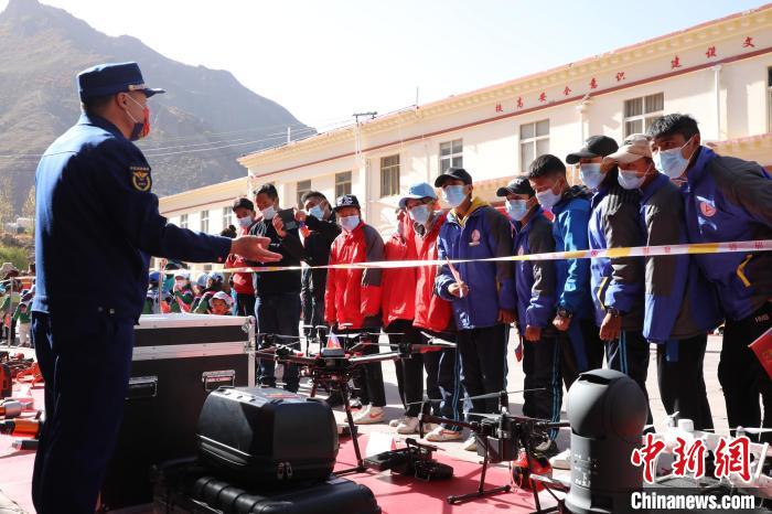 圖為消防指戰(zhàn)員為學(xué)生講解、演示先進(jìn)救援裝備?！≮w琳 攝