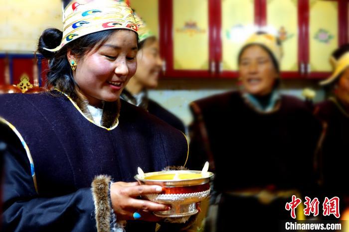 圖為藏族姑娘向客人敬酒?！∪轿木?攝