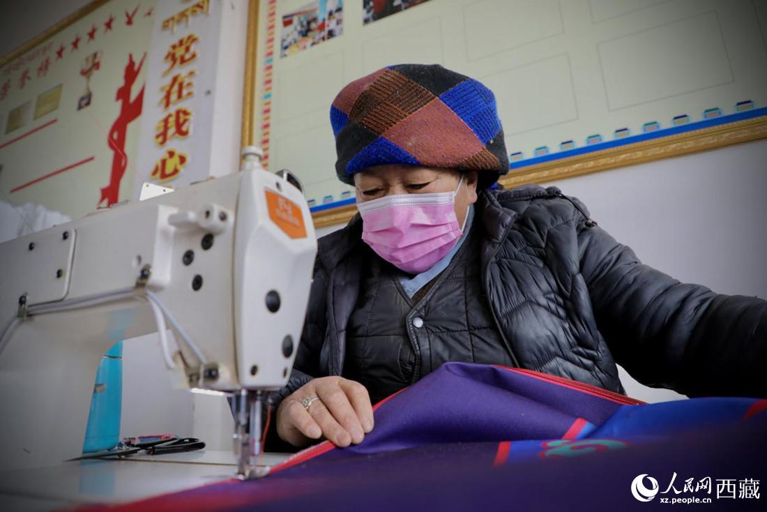 農(nóng)牧民專業(yè)合作社里的村民正在制作門簾。人民網(wǎng) 次仁羅布攝