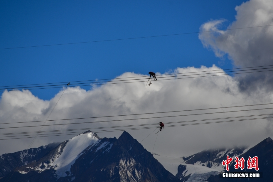 資料圖為2020年6月23日，西藏阿里聯(lián)網工程施工人員在日喀則希夏邦馬雪山附近進行走線作業(yè)，安裝絕緣設備。 <a target='_blank' href='/'><p  align=