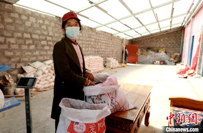 圖為寧重崗村村民扎西才措把自家的油菜籽送到合作社銷售?！〖卫杩h融媒體中心供圖