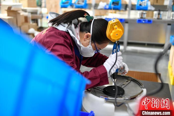 圖為工人正在組裝炊具?！∝暩聛?lái)松 攝