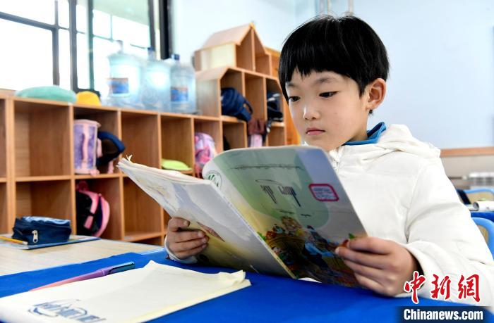 3月14日，西藏拉薩市第一小學(xué)一年級六班學(xué)生丁增樂吉在閱讀藏語課本。　李林 攝