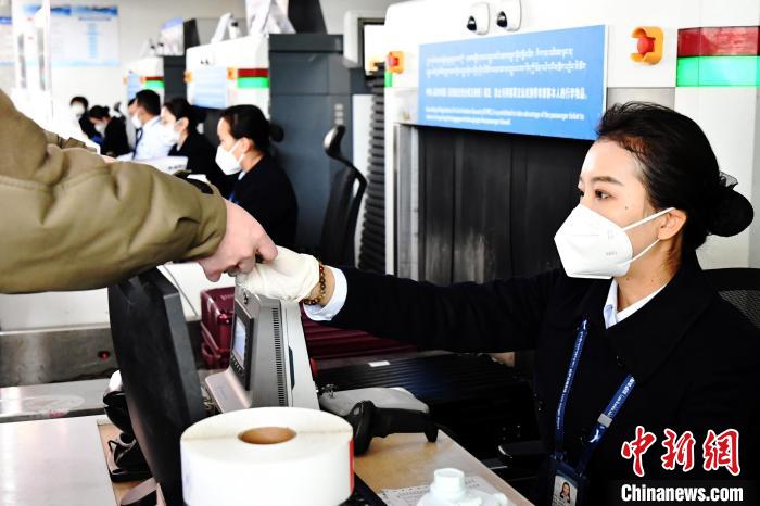 圖為機場工作人員為旅客辦理行李托運。　周航 攝