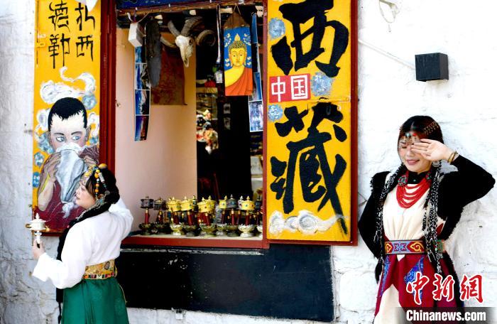 4月17日，游客身著藏式元素服裝在拉薩八廓街拍照留念?！±盍?攝
