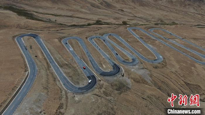 圖為騎手前往珠峰大本營途經(jīng)108道拐?！∮文恋厍蚬﹫D