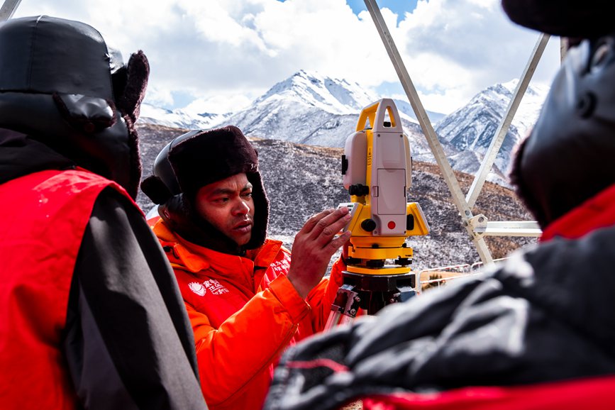 2023年11月30日，西藏自治區(qū)那曲市索縣榮布至丁青縣巴達(dá)35千伏線(xiàn)路工程負(fù)責(zé)人黃小洪（左二）現(xiàn)場(chǎng)開(kāi)展線(xiàn)路弧測(cè)量教學(xué)。趙清鵬攝