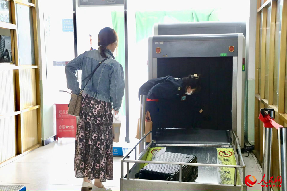 車站工作人員幫旅客提取行李。人民網(wǎng)記者 次仁羅布攝