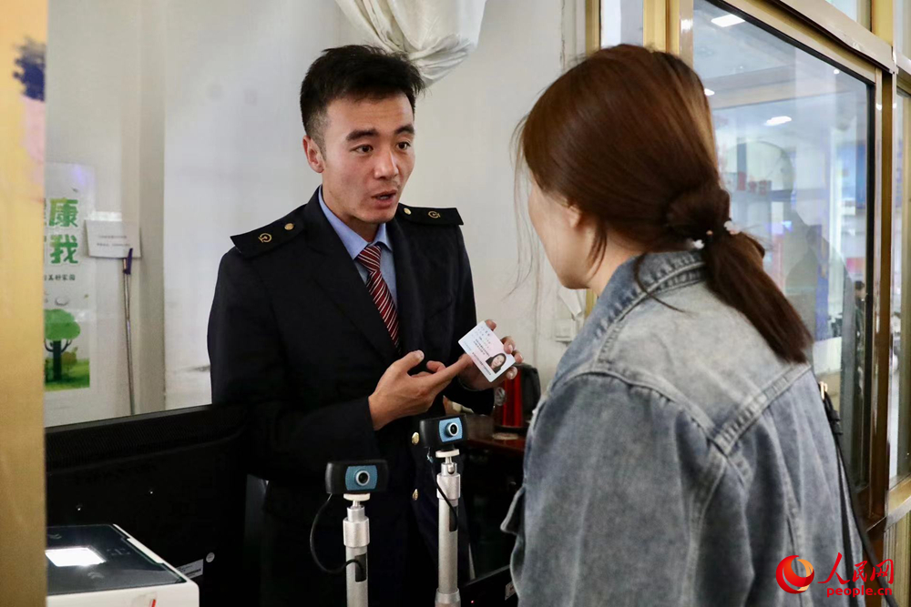 車站工作人員向旅客解答疑問。人民網(wǎng)記者 次仁羅布攝