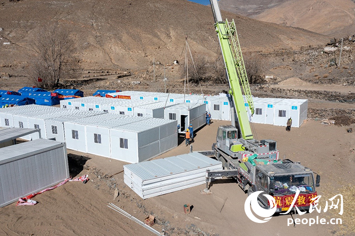1月9日，在日喀則市定日縣長(zhǎng)所鄉(xiāng)古榮村安置點(diǎn)，救援人員和施工人員合力抓緊搭建移動(dòng)板房，確保受災(zāi)群眾溫暖過冬。人民網(wǎng)記者 翁奇羽攝